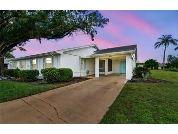 Charming single-story home featuring a covered carport, white exterior, and manicured landscaping at 2301 Grenoble Pl # 1, Sun City Center, FL 33573