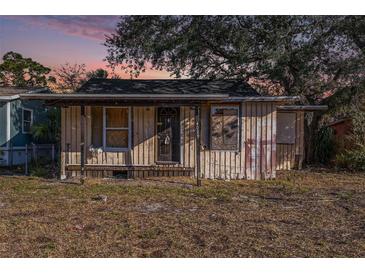 Exterior view of a single-story home with a weathered facade and a small front porch at 4029 13Th S Ave, St Petersburg, FL 33711