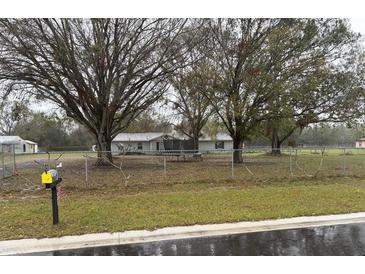 Quaint single-story home featuring a trampoline and a chain link fence around the front yard at 6622 Grace Sweat Rd, Riverview, FL 33578