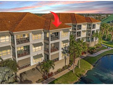 Three-story waterfront condo featuring balconies, neutral paint, and a terracotta-colored tile roof at 1026 Bellasol Way # 4403, Apollo Beach, FL 33572