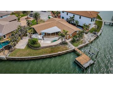 Aerial view of a waterfront home with a private pool, boat dock and lift at 11697 Grove St, Seminole, FL 33772