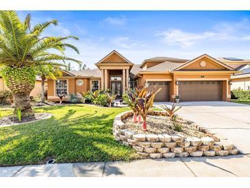 Stunning home with a three-car garage, manicured landscaping, and a beautiful palm tree in the front yard at 16410 Ivy Lake Dr, Odessa, FL 33556