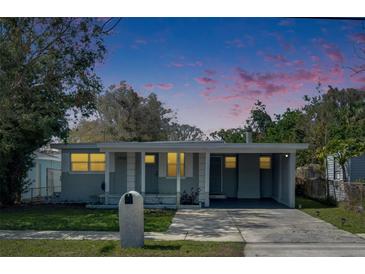 Charming single-story home featuring a carport, well-maintained lawn, and inviting front porch under a colorful sky at 1940 N Betty Ln, Clearwater, FL 33755