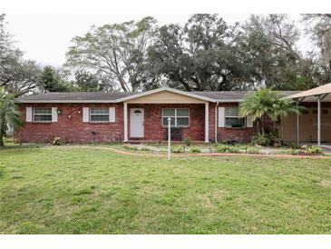 Charming brick home with a well-manicured lawn and mature trees at 204 Amana Ave, Brandon, FL 33510