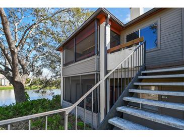 Condo building exterior with stairs leading up to the units and a glimpse of the lake at 10263 Gandy N Blvd # 2014, St Petersburg, FL 33702