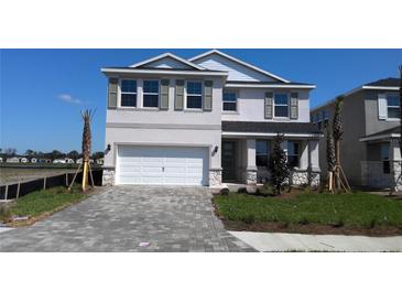 Charming two-story home with a paved driveway, manicured lawn, and a two-car garage at 1741 Cobb Trl, Parrish, FL 34219