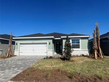 Charming single-story home featuring a paver driveway, two-car garage, and manicured lawn at 17049 James Trl, Parrish, FL 34219
