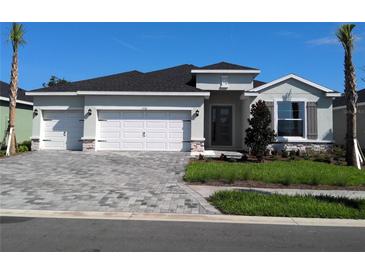 Charming one-story home with three-car garage, stone accents, and manicured landscaping at 17126 James Trl, Parrish, FL 34219