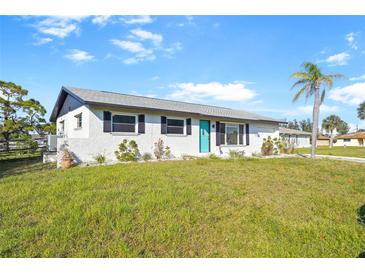 Charming single-story home with a well-maintained lawn and inviting blue front door at 184 Garden Nw Ave, Port Charlotte, FL 33952