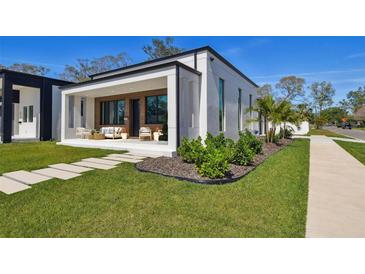 Charming modern home with a covered porch featuring stylish outdoor seating and a beautifully landscaped front yard at 4501 24Th S Ave, St Petersburg, FL 33711