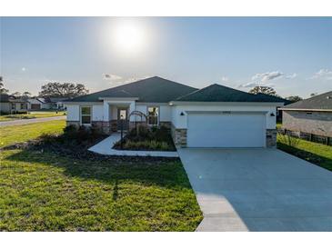Beautiful single-story home featuring stone accents, manicured landscaping, and a spacious two-car garage at 5433 Chestnut Ridge Rd, Dade City, FL 33523