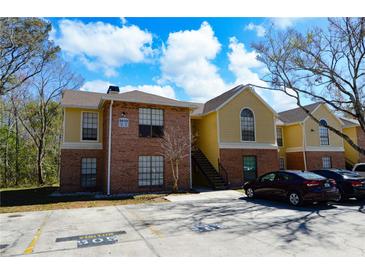 Charming two-story condo building with brick and siding exterior and ample parking at 8659 Fancy Finch Dr # 202, Tampa, FL 33614