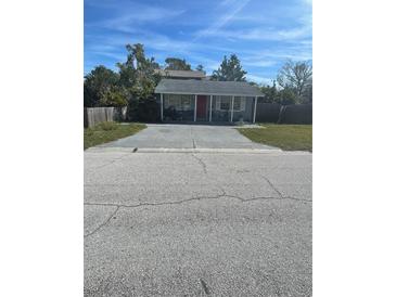 Charming single-story home with a red front door and a spacious driveway at 300 W 52Nd S St, St Petersburg, FL 33707