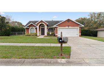 Charming single-story home boasts a well-manicured lawn, beautiful landscaping and an attached two-car garage at 38944 Carr Dr, Zephyrhills, FL 33540