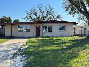 Charming single-story home with a well-manicured lawn and cozy front porch at 6213 N Cameron Ave, Tampa, FL 33614