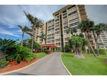 A luxurious condo community with beautiful tropical landscaping and paver driveway at 700 Island Way # 404, Clearwater Beach, FL 33767