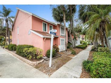 Charming pink condo with lush landscaping and clear signage on a sunny day in a desirable neighborhood at 3600 42Nd S St # 52B, St Petersburg, FL 33711