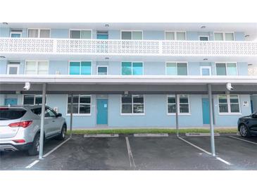 Bright blue condo building featuring covered parking, a second-story balcony, and neatly maintained landscaping at 4715 Bay Ne St # 126, St Petersburg, FL 33703