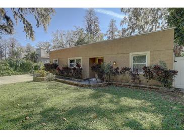 Charming single-story home with mature landscaping, a tan stucco exterior, and updated windows at 5704 Half Moon Lake Rd, Tampa, FL 33625