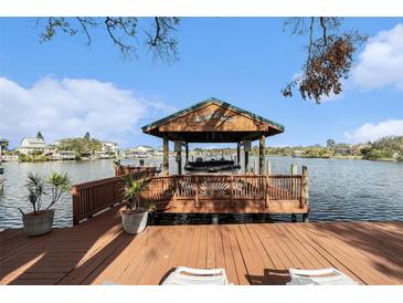 Waterfront property featuring a private boat dock with a boat lift offering direct access to the open water and boating activities at 9920 Alavista Dr, Gibsonton, FL 33534