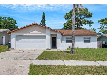Charming one-story home with a well-maintained lawn and attached garage, perfect for a starter home or downsizing at 105 Lotus Cir, Safety Harbor, FL 34695