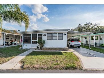 Charming single-story home with a well-maintained lawn and covered parking at 37042 Lois Ave, Zephyrhills, FL 33542