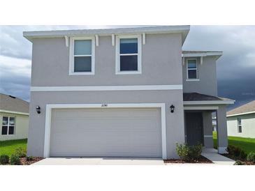 Charming two-story home featuring a large garage, neutral paint, and well-maintained landscaping at 10741 Hidden Banks Gln, Parrish, FL 34219