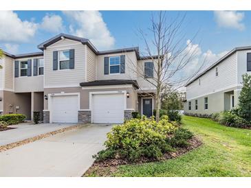 Charming two-story townhome with a one car garage, neutral exterior paint and well maintained landscaping at 21404 Darter Rd, Land O Lakes, FL 34638