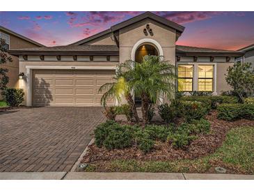 Charming single-Gathering home with a well-manicured front yard and brick paver driveway at 4016 Cadence Loop, Land O Lakes, FL 34638