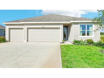 Charming single-Gathering home featuring a manicured lawn and a three-car garage at 17468 Whiskey Creek Trl, Parrish, FL 34219
