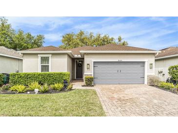 Charming single-story home featuring a well-maintained lawn, brick driveway, and a neutral color scheme at 25325 Welsh Poppy Way, Land O Lakes, FL 34639