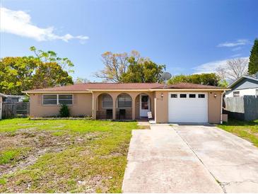 Charming single-story home featuring a large driveway, a one-car garage, and a well-maintained lawn at 5117 School Rd, New Port Richey, FL 34653