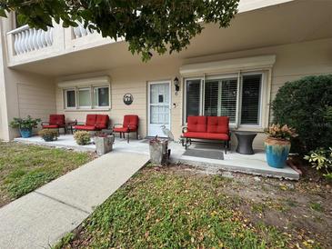 Inviting front porch featuring red patio furniture and a walkway to the front door at 2170 Americus S Blvd # 6, Clearwater, FL 33763