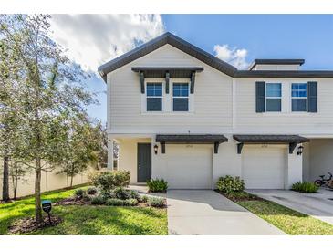 Charming townhome with a well-manicured lawn, inviting entrance, and attached garages under a sunny sky at 2710 Chestnut Creek Pl, Brandon, FL 33510