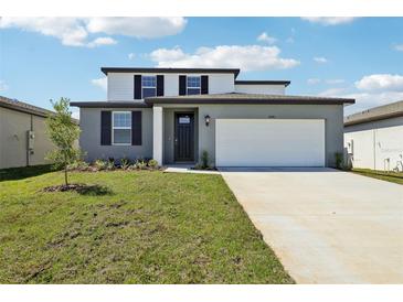 Charming two-story home featuring a well-manicured lawn, attached two car garage and a modern exterior color scheme at 31640 Malbec Dr, Brooksville, FL 34602