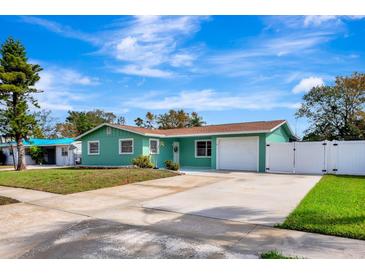 Charming green single-story home featuring a well-manicured lawn, long driveway, and attached garage at 3543 Stokes Dr, Sarasota, FL 34232