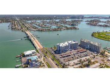 Aerial view showcasing condo buildings next to the water, featuring a nearby bridge at 500 Treasure Island Cswy # 207, Treasure Island, FL 33706