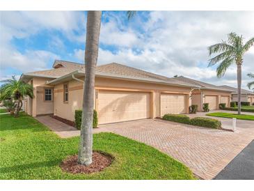 A lovely home with a brick driveway, attached garage, lush landscaping and a beautiful lawn at 9808 62Nd N Ter # 9808, St Petersburg, FL 33708