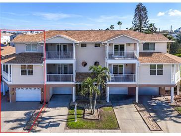 The exterior of the home shows screened balconies, garage spaces, and nicely kept landscaping at 227 126Th Ave, Treasure Island, FL 33706