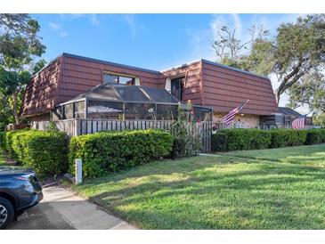 Charming townhome with well-manicured lawn, screened patio, and American flags waving at 2612 6Th Ct, Palm Harbor, FL 34684