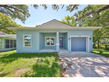 Charming blue single-story home with a well-manicured front yard and a single-car garage at 3409 E 11Th Ave, Tampa, FL 33605