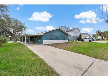 Charming single story home with teal and white paint, covered parking, and long driveway at 4638 Heavens Way, New Port Richey, FL 34652