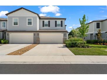 Charming townhome with a two-car garage, well-maintained landscaping, and neutral paint scheme at 5994 Shiner St, Land O Lakes, FL 34638