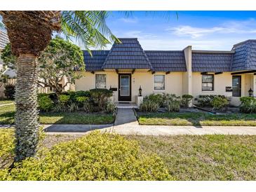 Charming townhouse featuring a unique roofline, well-maintained landscaping, and a welcoming entrance at 2101 Cordova Grn, Seminole, FL 33777