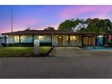 Charming single-story home featuring brick facade, well-manicured lawn and convenient covered parking at 7213 Trinity Pl, Tampa, FL 33610