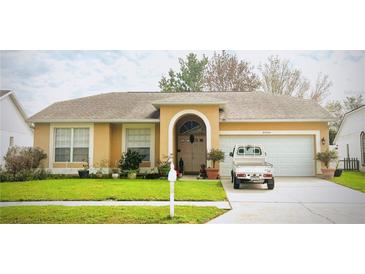 Charming single-story home featuring a well-manicured lawn and a two-car garage at 24604 Laurel Ridge Dr, Lutz, FL 33559