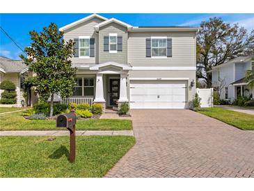 Charming two-story home featuring a manicured lawn, brick driveway, and an attached two-car garage at 3605 W Santiago St, Tampa, FL 33629