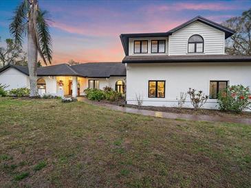 Charming two-story home with manicured lawn, black trim windows, and lush landscaping at 4588 Baycedar Ln, Sarasota, FL 34241