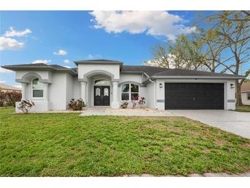 Charming single-story home with a well-manicured lawn and a two-car garage at 6140 Silver Oaks Dr, Zephyrhills, FL 33542