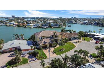 Stunning aerial view of waterfront home with lush landscaping, boat dock, and panoramic views of the bay at 7986 9Th S Ave, St Petersburg, FL 33707